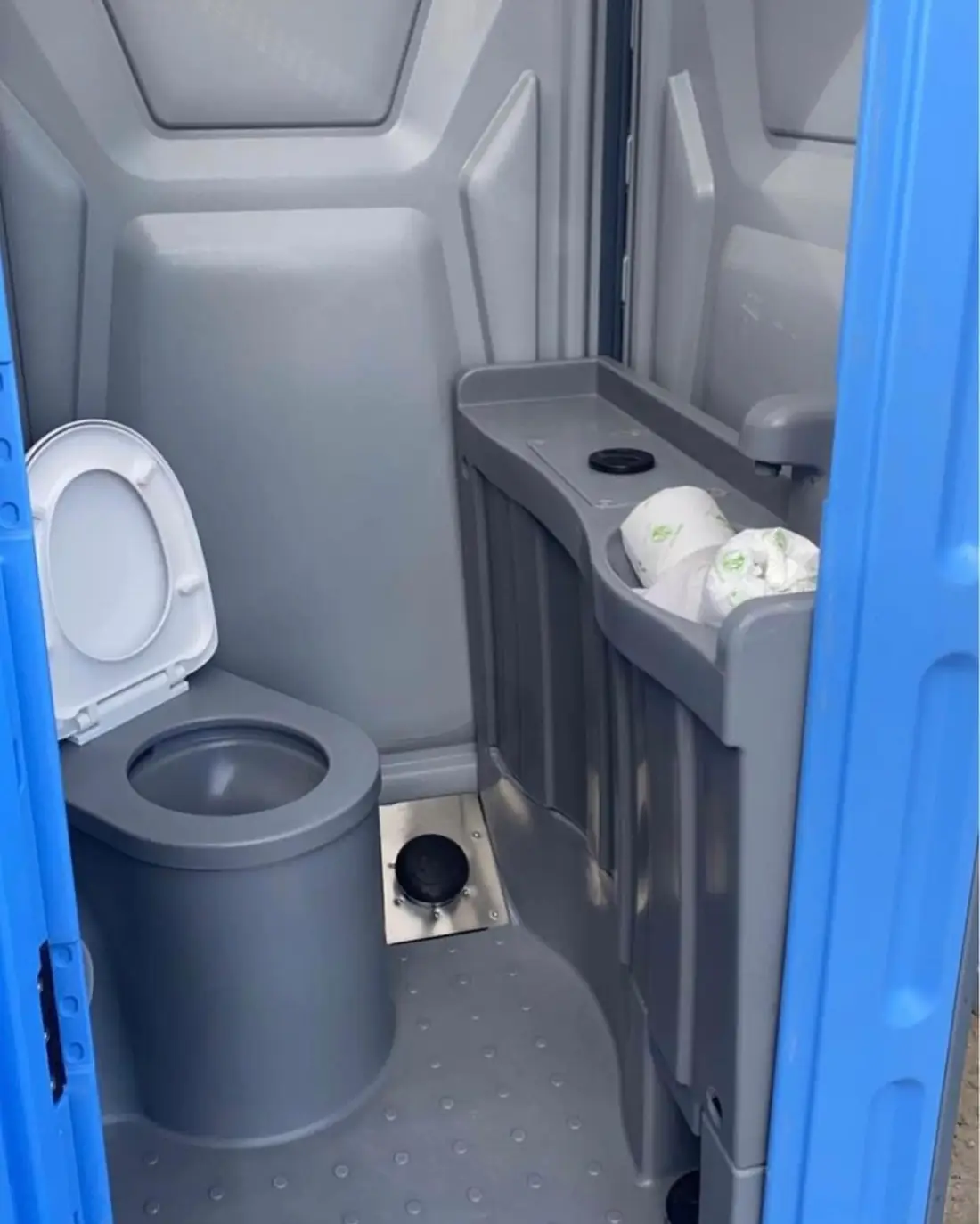 Inside a deluxe portable toilet with sink and flushing toilet