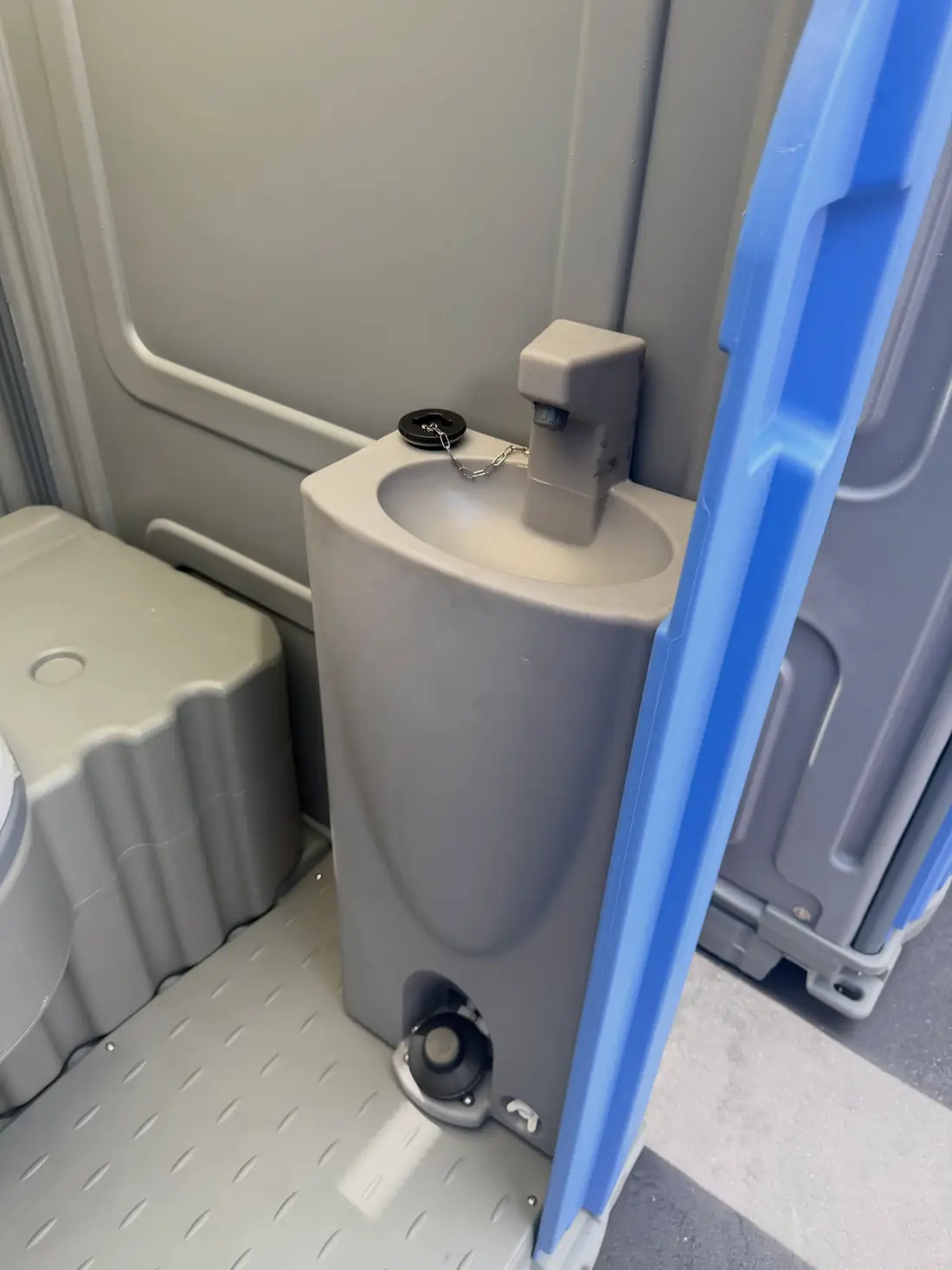 Foot-pump sink inside a portable restroom unit