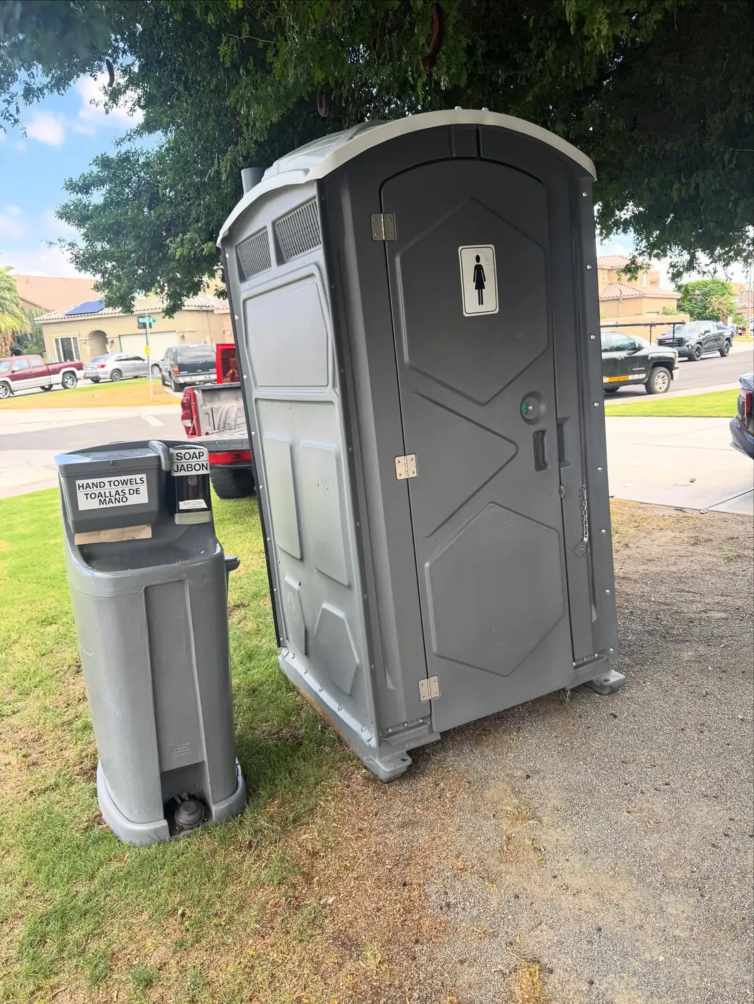 Porta potty with a hand washing station beside it